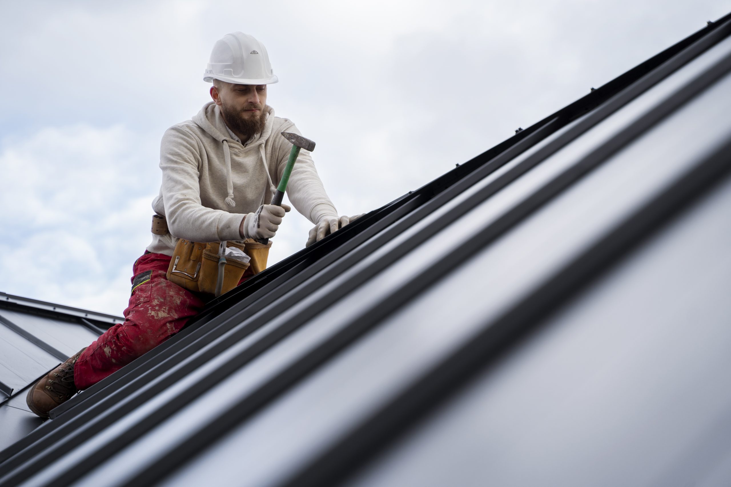 Roofer inspecting asphalt shingles on a roof